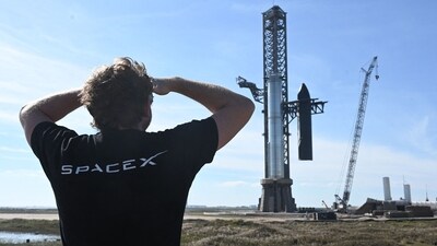 A person looks on as SpaceX's huge Super Heavy-Starship is unstacked from the booster as it sits on the launchpad at Starbase in Boca Chica, Texas, on November 16, 2023, ahead of its second test flight posponed to November 18. (AFP) A person looks on as SpaceX's huge Super Heavy-Starship is unstacked from the booster as it sits on the launchpad at Starbase in Boca Chica, Texas, on November 16, 2023, ahead of its second test flight posponed to November 18. (AFP)