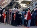 Palestinian women line up to buy fresh bread next to destroyed buildings at the Nuseirat refugee camp in the central Gaza Strip on November 4, 2023. Palestinian women line up to buy fresh bread next to destroyed buildings at the Nuseirat refugee camp in the central Gaza Strip on November 4, 2023.