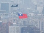 China-Taiwan Conflict: A Chinook helicopter carrying a Taiwan flag flies over the city during the country's National Day celebration in Taipei, Taiwan.