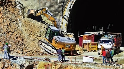 A heavy machinery works at the entrance to the site of an under-construction road tunnel that collapsed in Uttarakhand, on Saturday. (AP) A heavy machinery works at the entrance to the site of an under-construction road tunnel that collapsed in Uttarakhand, on Saturday. (AP)