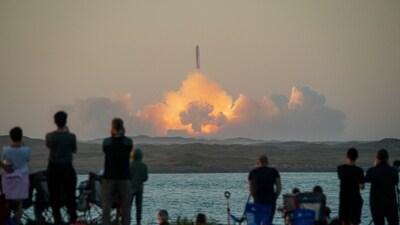 People watch as SpaceX's next-generation Starship spacecraft atop its powerful Super Heavy rocket lifts off from the company's Boca Chica launchpad in Texas on November 18. (Reuters)