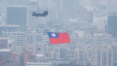 China-Taiwan Conflict: A Chinook helicopter carrying a Taiwan flag flies over the city during the country's National Day celebration in Taipei, Taiwan. (Reuters)