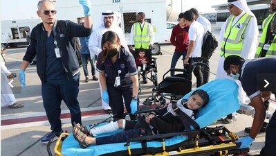 Volunteers transport a wounded Palestinian child off the plane upon arrival in Abu Dhabi. (AFP)