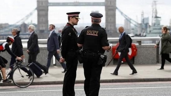 Commuters travel past City of London police officers standing on London Bridge. (Representational)