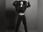 One of the pictures shows Jungkook in a cropped tank top showing off killer abs, layered with a denim jacket and matching denim jeans. He styled the ensemble with Chelsea boots, a scarf wrapped around his neck, hoop earrings, and rings. His retro-inspired curly locks stole the show. One of the pictures shows Jungkook in a cropped tank top showing off killer abs, layered with a denim jacket and matching denim jeans. He styled the ensemble with Chelsea boots, a scarf wrapped around his neck, hoop earrings, and rings. His retro-inspired curly locks stole the show. 