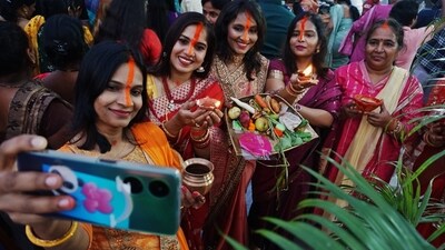 Women observing Chhath rituals near Brahamand Lake, Ghodbander Road in Thane, capturing a selfie on Sunday. (Praful Gangude/HT Photo)