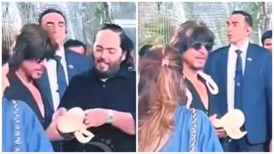 Anant Ambani hands Shah Rukh Khan a snake (left), actor seen with one more snake around his neck (right). Anant Ambani hands Shah Rukh Khan a snake (left), actor seen with one more snake around his neck (right).