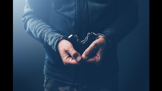 Arrested computer hacker and cyber criminal with handcuffs, close up of hands (Getty Images/iStockphoto)