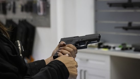 A customer holds a gun for sale at a store in Pompano Beach, Florida, US, on Wednesday, Oct. 25, 2023. Anxiety about antisemitism is causing some people to rethink their reluctance to own a firearm and the Sunshine State's laws make it easier to obtain one. (Bloomberg)