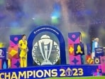 Pat Cummins standing along on stage with the World Cup trophy. 