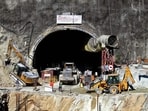 Rescue workers stand at an entrance of the under-construction road tunnel, days after it collapsed in the Uttarkashi district.