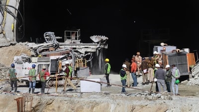 Uttarkashi: Security personnel and others at the under-construction tunnel between Silkyara and Dandalgaon on the Brahmakhal-Yamunotri national highway, days after a portion of the tunnel collapsed trapping several workers inside. (PTI) Uttarkashi: Security personnel and others at the under-construction tunnel between Silkyara and Dandalgaon on the Brahmakhal-Yamunotri national highway, days after a portion of the tunnel collapsed trapping several workers inside. (PTI)