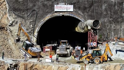 Rescue workers stand at an entrance of the under-construction road tunnel, days after it collapsed in the Uttarkashi district. (AFP)