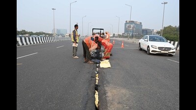 Workers of NHAI repair the crack on Iffco Chowk parallel flyover in Gurugram on Monday. (Parveen Kumar/HT Photo)