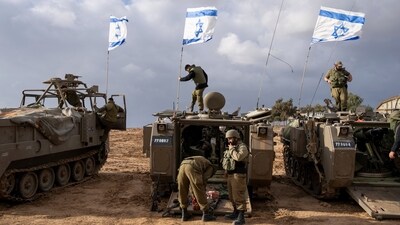 Israeli soldiers work on armored military vehicles along Israel's border with the Gaza Strip, in southern Israel. (AP) Israeli soldiers work on armored military vehicles along Israel's border with the Gaza Strip, in southern Israel. (AP)