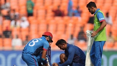 Afghanistan's Ibrahim Zadran changes his shoes during the match (REUTERS)