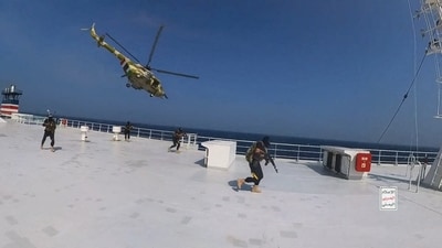 Houthi military helicopter hovers over the Galaxy Leader cargo ship as Houthi fighters walk on the ship's deck in the Red Sea in this photo released November 20. (REUTERS)
