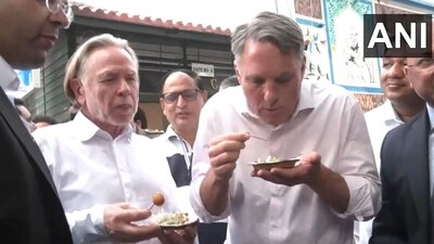 Australian Deputy PM Richard Marles enjoying ram laddu along with other officials. (X/ANI)