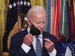 U.S. President Joe Biden removes his face mask prior to awarding the Medal of Honor to retired Army Captain Larry Taylor for conspicuous gallantry during the Vietnam War, during a ceremony in the East Room at the White House in Washington, U.S., September 5, 2023.