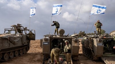 Israeli soldiers work on armored military vehicles along Israel's border with the Gaza Strip, in southern Israel. (AP) Israeli soldiers work on armored military vehicles along Israel's border with the Gaza Strip, in southern Israel. (AP)