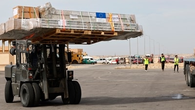 Workers unload humanitarian aid at Egypt's al-Arish Airport on November 22. (AFP)