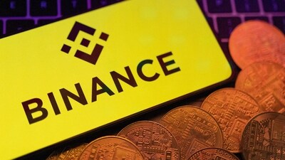 Smartphone with displayed Binance logo and representation of cryptocurrencies are placed on a keyboard in this illustration (REUTERS)
