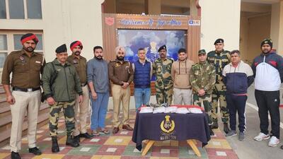 Punjab Police and Border Security Force personnel who recovered 5.2kg of heroin dropped by a drone which sneaked into Indian airspace from Pakistan on Wednesday. The heroin was recovered from a field near the Attari-Wagah border near Amritsar. (HT Photo)