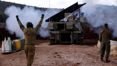 A soldier gestures as an Israeli artillery unit in Upper Galilee in northern Israel fires toward southern Lebanon on November 22, 2023. (AFP)