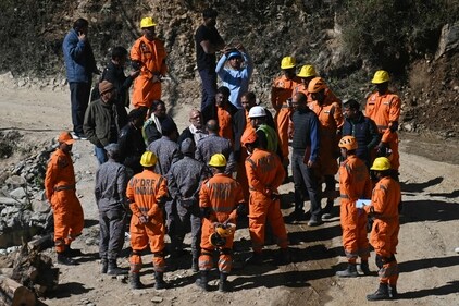 National Disaster Response Force (NDRF) personnel interact with officials during the rescue operation for trapped constructions workers days. (AFP)