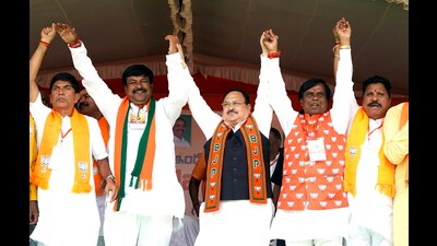 Bharatiya Janata Party (BJP) national president JP Nadda holds hands with party leaders during a public rally for the Telangana Assembly Elections, in Nizamabad on Thursday. (ANI)