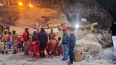 Uttarkashi: Security and media personnel gather around a bonfire during the rescue operation of 41 workers trapped inside the Silkyara tunnel, in Uttarkashi. (PTI) Uttarkashi: Security and media personnel gather around a bonfire during the rescue operation of 41 workers trapped inside the Silkyara tunnel, in Uttarkashi. (PTI)
