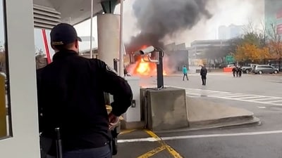 A Customs and Border Protection officer watches as a vehicle burns at the Rainbow Bridge U.S. border crossing with Canada, in Niagara Falls, New York, U.S. November 22, 2023.  Courtesy Saleman Alwishah via REUTERS (via REUTERS)
