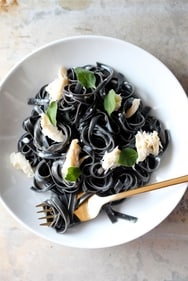 Squid ink pasta, an exquisite delicacy, boasts a rich, briny flavor and a striking black hue, making it a visually captivating and gastronomically indulgent choice. (Pinterest)