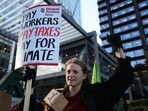 A demonstrator holds a placard during a protest outside the Amazon headquarters during Black Friday in London, Britain, November 24, 2023.