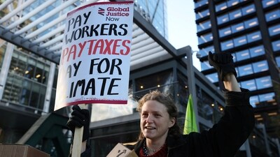 A demonstrator holds a placard during a protest outside the Amazon headquarters during Black Friday in London, Britain, November 24, 2023. (REUTERS)