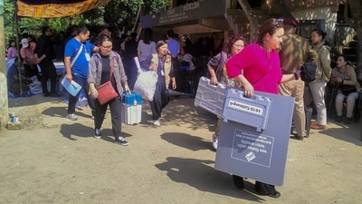Polling officials with EVMs and other election material. (PTI) Polling officials with EVMs and other election material. (PTI)