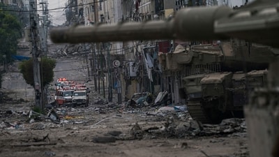 Ambulances are seen on a road near an Israeli forces tank during an Israeli army ground operation in the Gaza Strip. (AP) Ambulances are seen on a road near an Israeli forces tank during an Israeli army ground operation in the Gaza Strip. (AP)