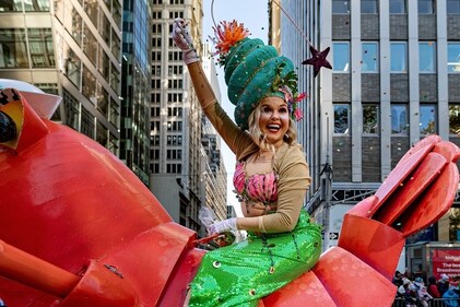A woman in a mermaid costume tosses confetti during the 97th Macy's Thanksgiving Day Parade in New York, Thursday, Nov. 23, 2023. (AP Photo/Peter K. Afriyie)
