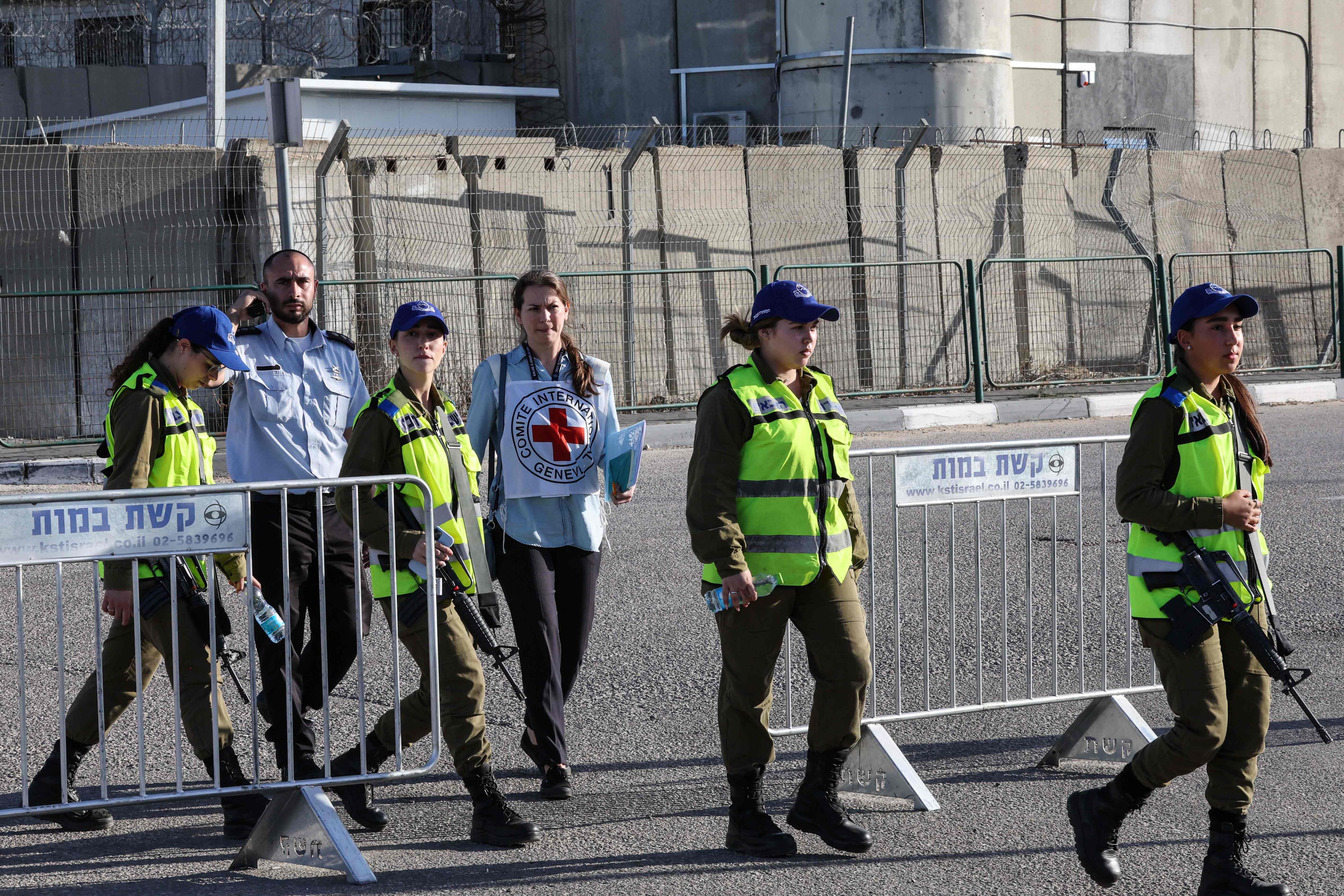 Israeli security forces and members of the International Red Cross are seen outside of the Ofer military camp near the occupied West Bank city of Ramallah, after transporting Palestinian prisoners from three Israeli jails. (AFP) Israeli security forces and members of the International Red Cross are seen outside of the Ofer military camp near the occupied West Bank city of Ramallah, after transporting Palestinian prisoners from three Israeli jails. (AFP)