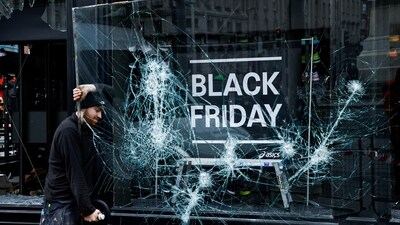 Dublin Knife Attack: A man works to remove a broken window from a sport shop that was damaged in a riot. (Reuters)