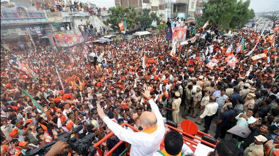 Union home minister Amit Shah waves at his supporters during a roadshow for the Telangana assembly elections, in Nalgonda (ANI)