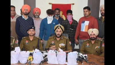 Police commissioner Gurpreet Singh Bhullar (C) with the recovered consignment and arrested accused in Amritsar on Sunday. (HT Photo)