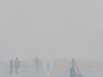 People visit Kartavya Path on a smoggy winter morning, in New Delhi on Monday. (PTI)