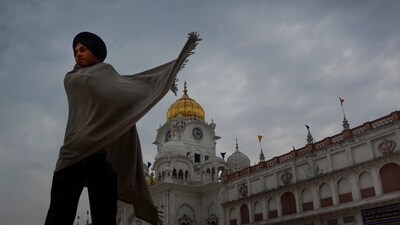 A Sikh devotee outside the Golden Temple as dark clouds hover in the sky in Amritsar on Monday. (PTI) A Sikh devotee outside the Golden Temple as dark clouds hover in the sky in Amritsar on Monday. (PTI)