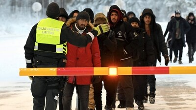 A Finnish Border Guard speaks to migrants at the international border crossing at Salla, northern Finland, on November 23, 2023. (AFP) A Finnish Border Guard speaks to migrants at the international border crossing at Salla, northern Finland, on November 23, 2023. (AFP)