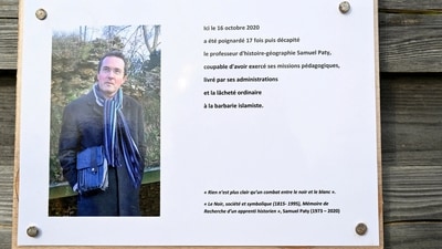 A commemorative plaque for slain teacher Samuel Paty (portrait) near the Bois d'Aulne school in Conflans-Sainte-Honorine, outside Paris. (Reuters)