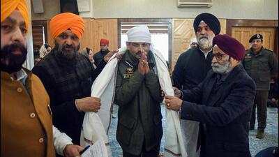 Jammu and Kashmir DGP RR Swain (centre) being felicitated after offering prayers at Gurdwara Chati Patshahi in Srinagar on the occasion of Guru Nanak Dev Jayanti on Monday. (ANI Photo)