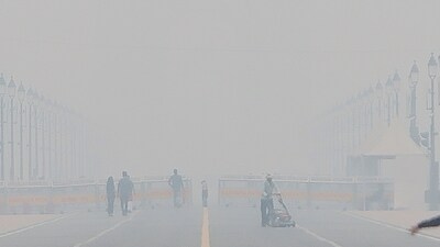 People visit Kartavya Path on a smoggy winter morning, in New Delhi on Monday. (PTI) People visit Kartavya Path on a smoggy winter morning, in New Delhi on Monday. (PTI)