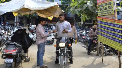 Parking attendants issuing tickets to visitors at an MC parking lot in Ludhiana. (Manish/HT)