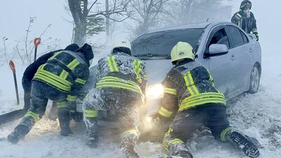 Emergency workers release a car stuck in snow during a heavy snowstorm in the Odesa region, Ukraine on November 27. (Reuters)